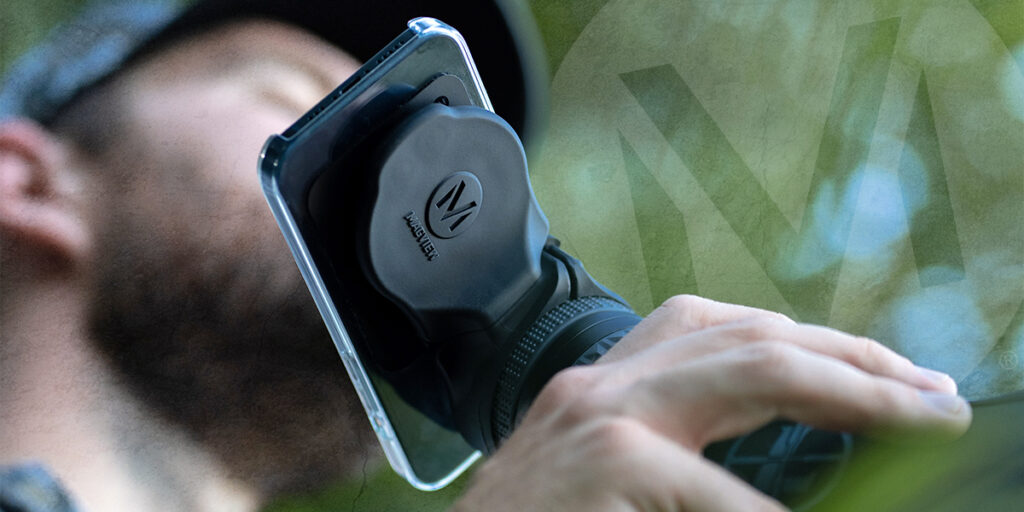 Hunter using a spotting scope equipped with MAGVIEW S1 to take pictures and video with cell phone.